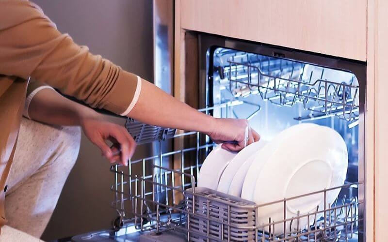 Lấy chén dĩa ra khỏi máy, bắt đầu từ khay trên xuống khay dưới